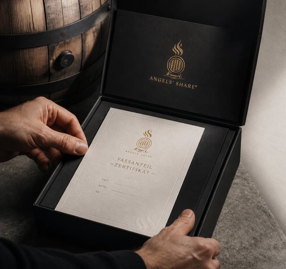 Geschenkvisualisierung: schwarze Angels’ Share Box mit goldgeprägtem Fassanteil-Zertifikat